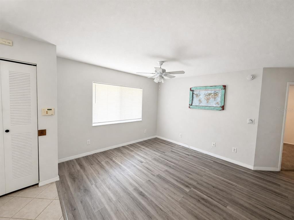 An empty room features light gray walls, wood-look flooring, a ceiling fan, and a window — 7904 WATERVIEW WAY, WINTER HAVEN, FL