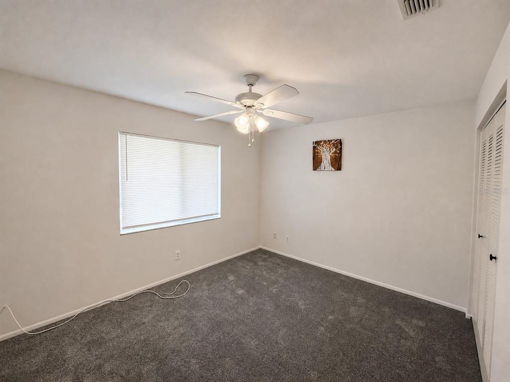 A bedroom with gray carpet, white walls, a ceiling fan, and a window with blinds — 7904 WATERVIEW WAY, WINTER HAVEN, FL