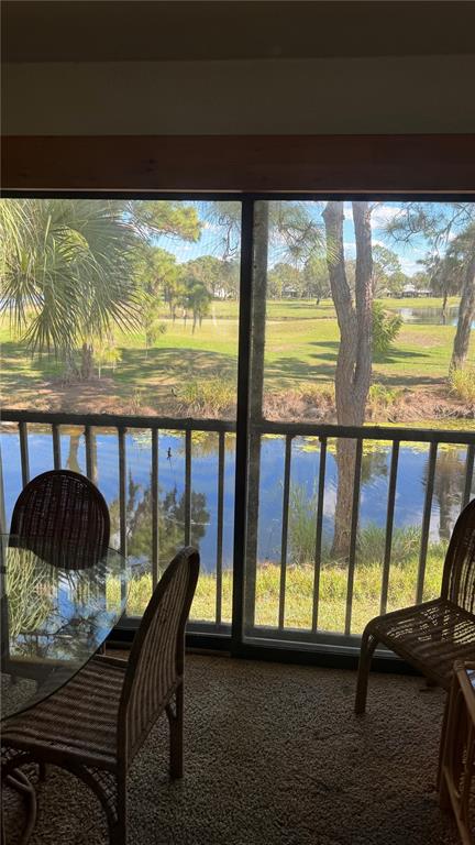 A screened-in balcony with wicker furniture overlooks a pond and a golf course — 4640 WEYBRIDGE UNIT 12, SARASOTA, FL