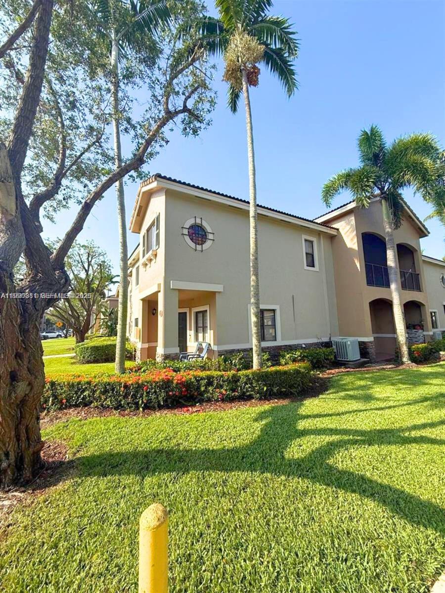 A two-story tan stucco building with a circular window and palm trees in front — 22711 SW 88th Pl # 23, Cutler Bay FL 33190, CUTLER BAY, FL