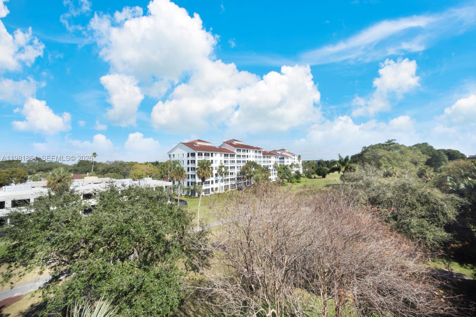 An exterior view shows a multi-story apartment building surrounded by trees and a grassy lawn — 800 Cypress Grove Dr # 509, Pompano Beach FL 33069, POMPANO BEACH, FL