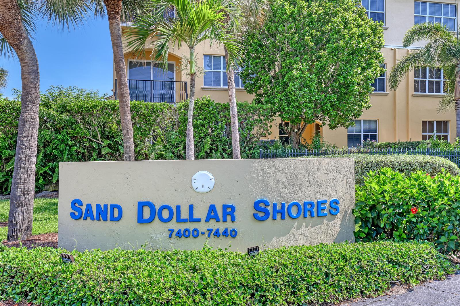 A beige sign with blue lettering stands in front of a multi-story apartment building — 7430 S Ocean Drive # 818, Jensen Beach FL 34957, JENSEN BEACH, FL