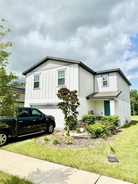 A two-story house with white siding and a black truck parked in the driveway — 3336 CURLEW AVENUE, LEESBURG, FL
