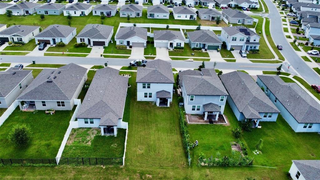 An aerial view shows several suburban houses with gray roofs and green lawns — 3336 CURLEW AVENUE, LEESBURG, FL