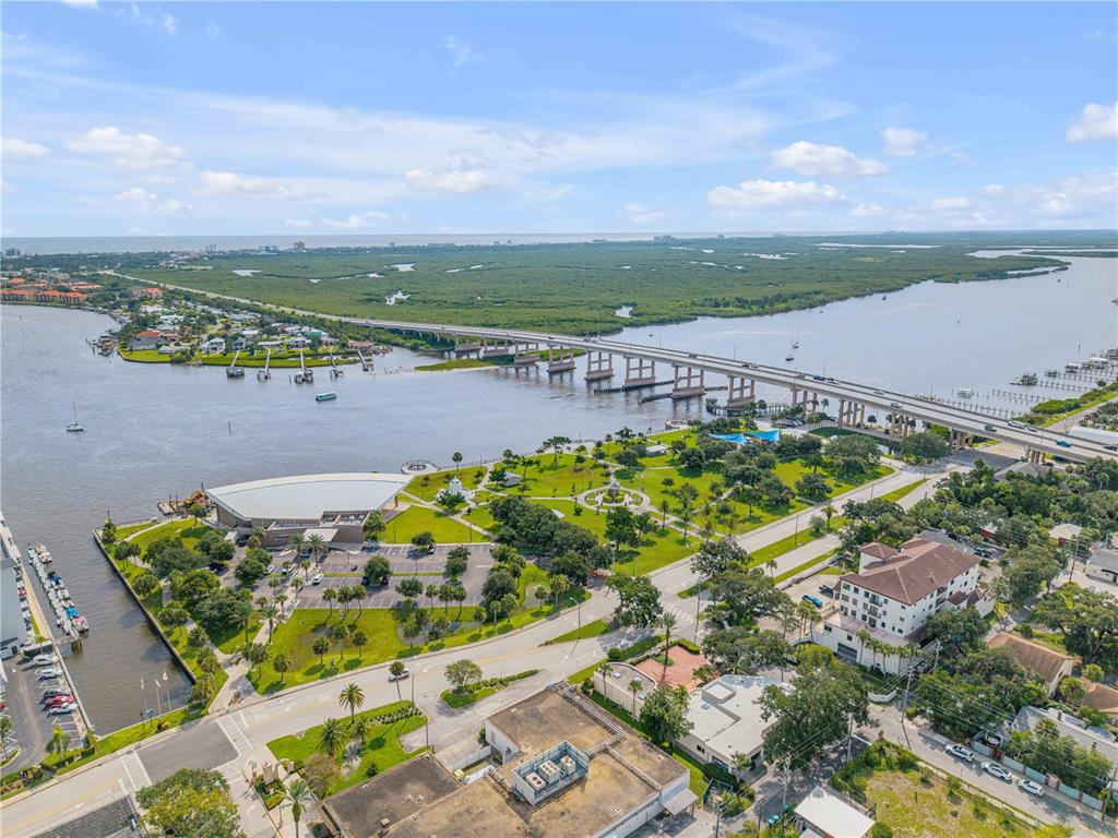 An aerial view shows a waterfront park, a bridge, and surrounding buildings — 200 LIVE OAK STREET, NEW SMYRNA BEACH, FL