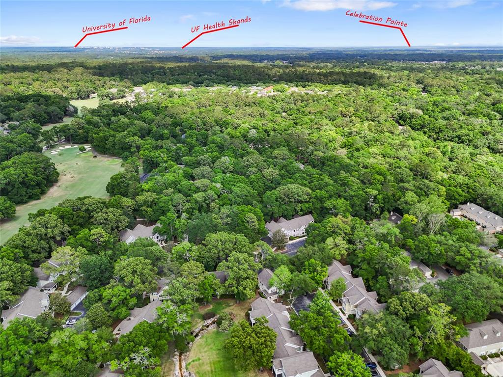 An aerial view shows a residential neighborhood surrounded by dense forest and a golf course — 10000 SW 52ND AVENUE UNIT 68, GAINESVILLE, FL