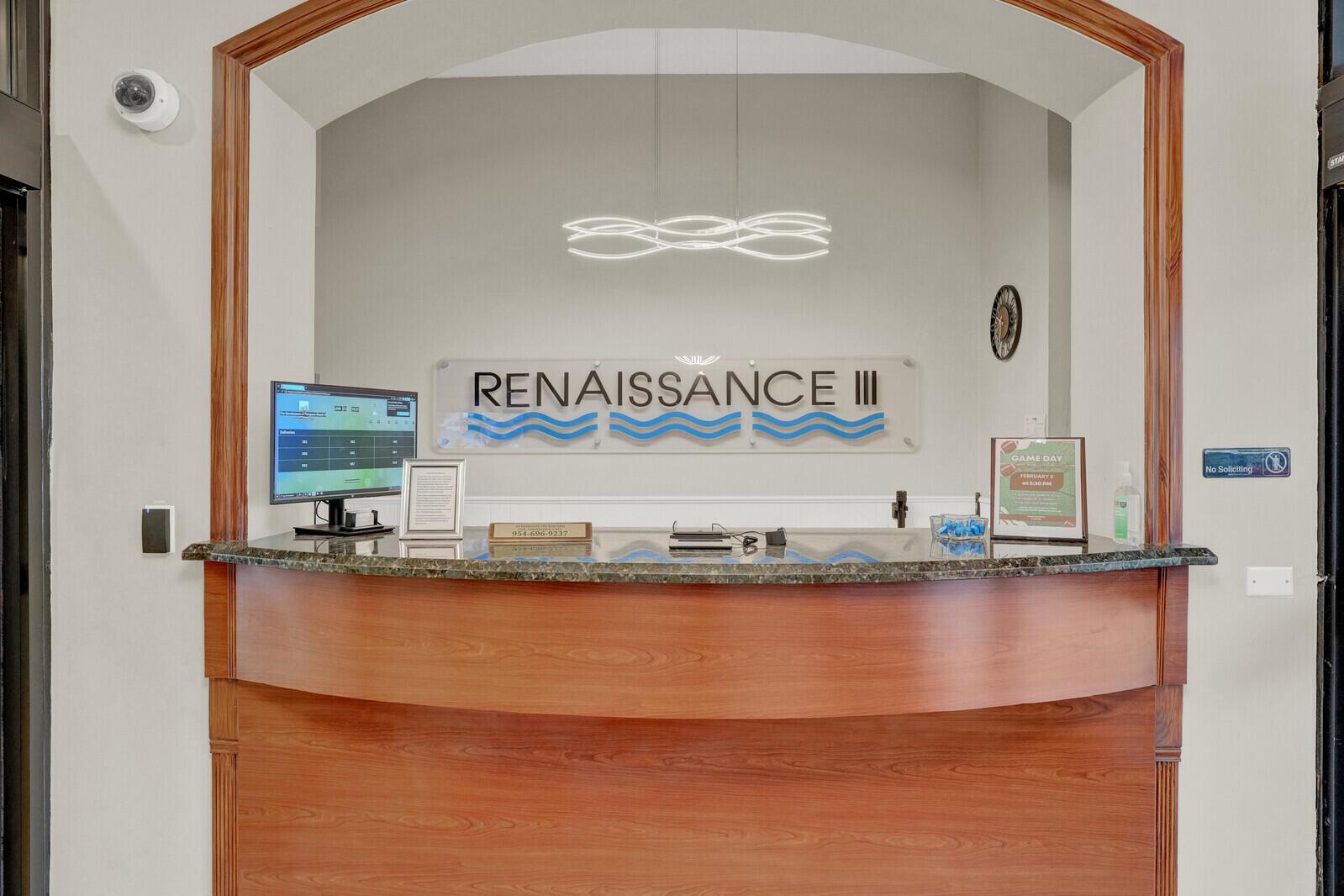 A wood-toned reception desk sits in front of a wall sign reading Renaissance III — 1361 S Ocean Boulevard, Pompano Beach FL 33062, POMPANO BEACH, FL