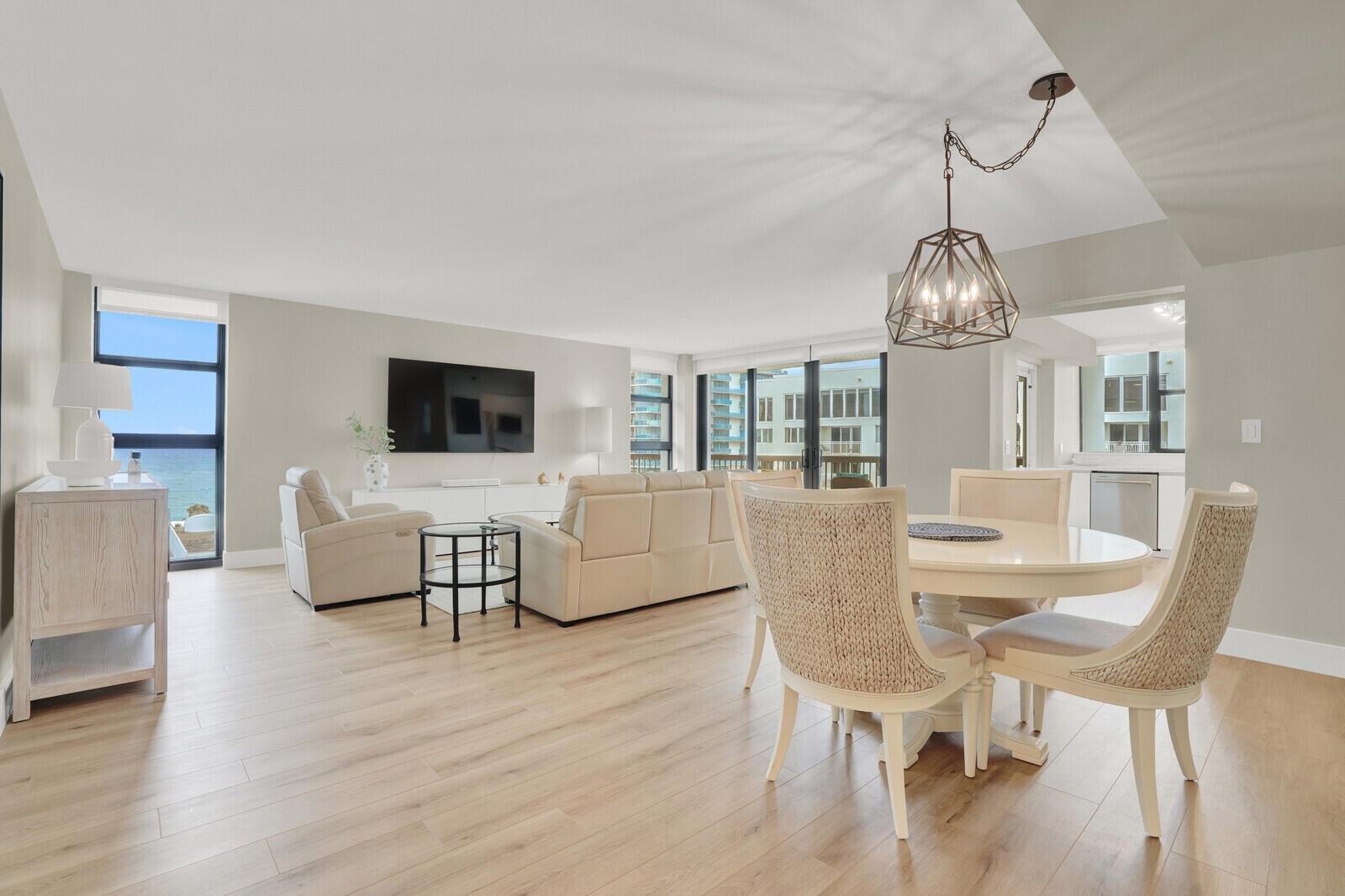 An open-concept living and dining area with light wood floors, neutral furniture, and ocean views — 1361 S Ocean Boulevard, Pompano Beach FL 33062, POMPANO BEACH, FL