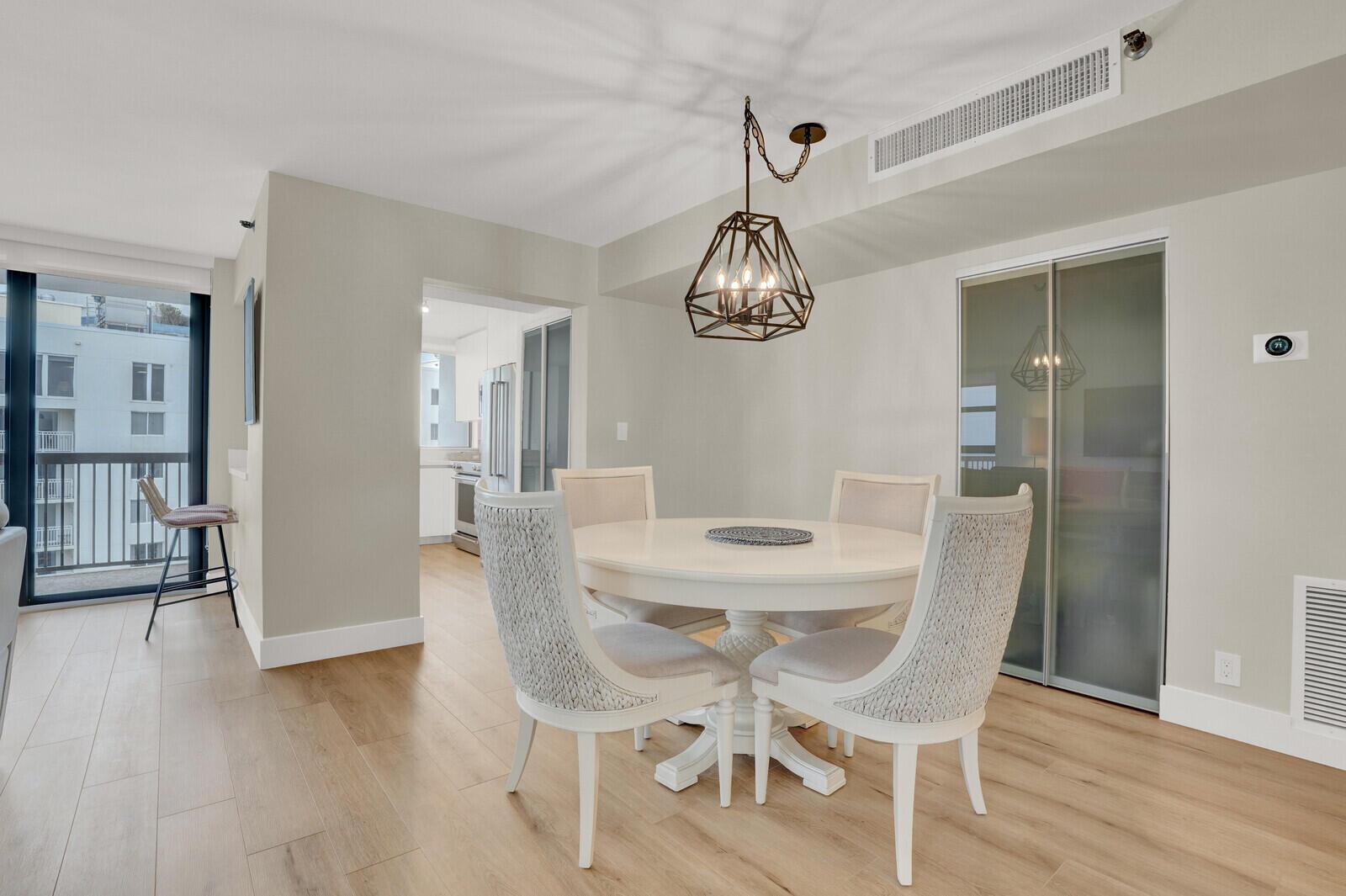A dining area features a round white table, four upholstered chairs, and a geometric pendant light — 1361 S Ocean Boulevard, Pompano Beach FL 33062, POMPANO BEACH, FL