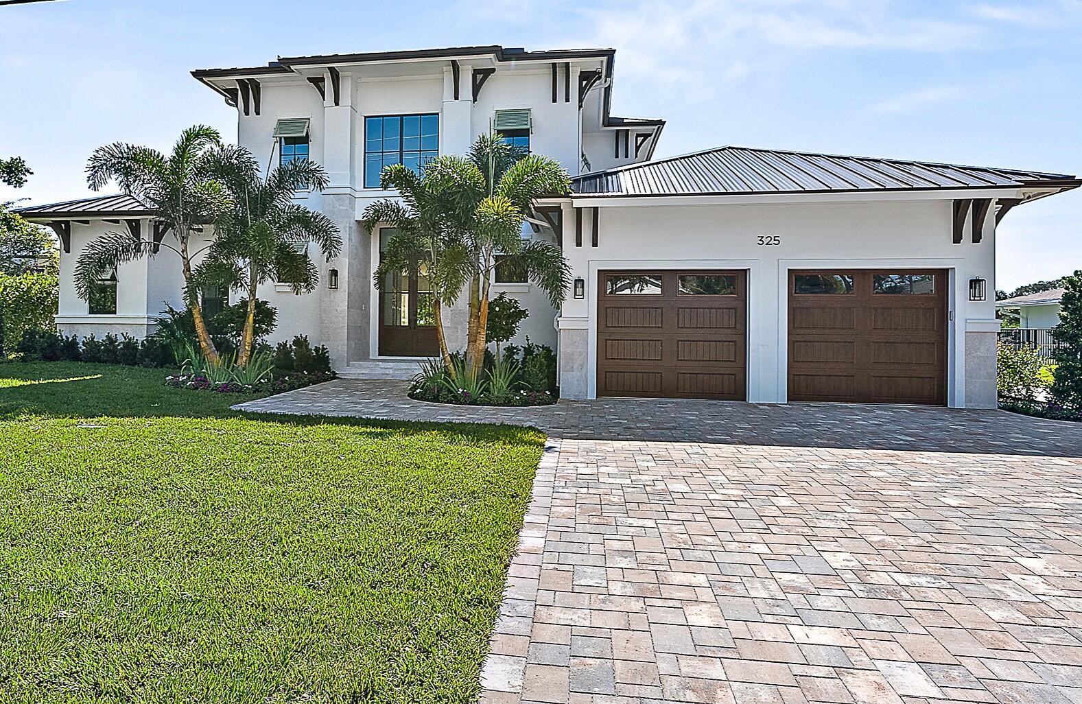 A two-story house with a white exterior, metal roof, and a two-car garage — 325 Fairway N, Tequesta FL 33469, TEQUESTA, FL