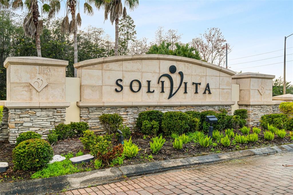 A single-story house with a beige stucco exterior, a paved walkway, and a palm tree — 661 CARMEL LANE, POINCIANA, FL
