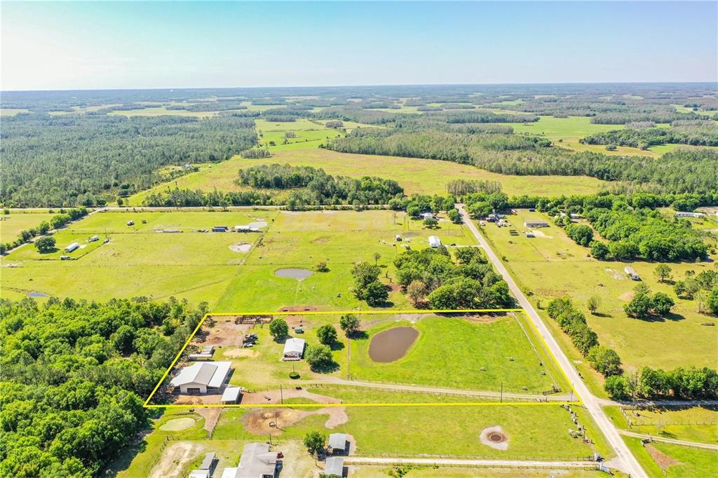 An aerial view shows a rural property with a house, outbuildings, and a pond — 14479 ANGUS ROAD, POLK CITY, FL