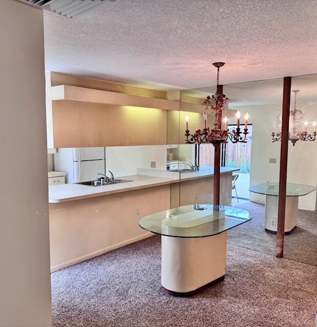 A kitchen with white countertops, light wood cabinetry, a glass-topped island, and mirrored walls — 217 Live Oak Lane, Boynton Beach FL 33436, BOYNTON BEACH, FL
