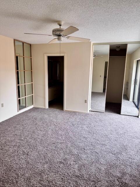 An empty bedroom features gray carpet, a ceiling fan, and mirrored closet doors — 217 Live Oak Lane, Boynton Beach FL 33436, BOYNTON BEACH, FL