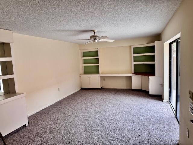 A living room features beige walls, gray carpeting, a ceiling fan, and built-in shelving units — 217 Live Oak Lane, Boynton Beach FL 33436, BOYNTON BEACH, FL