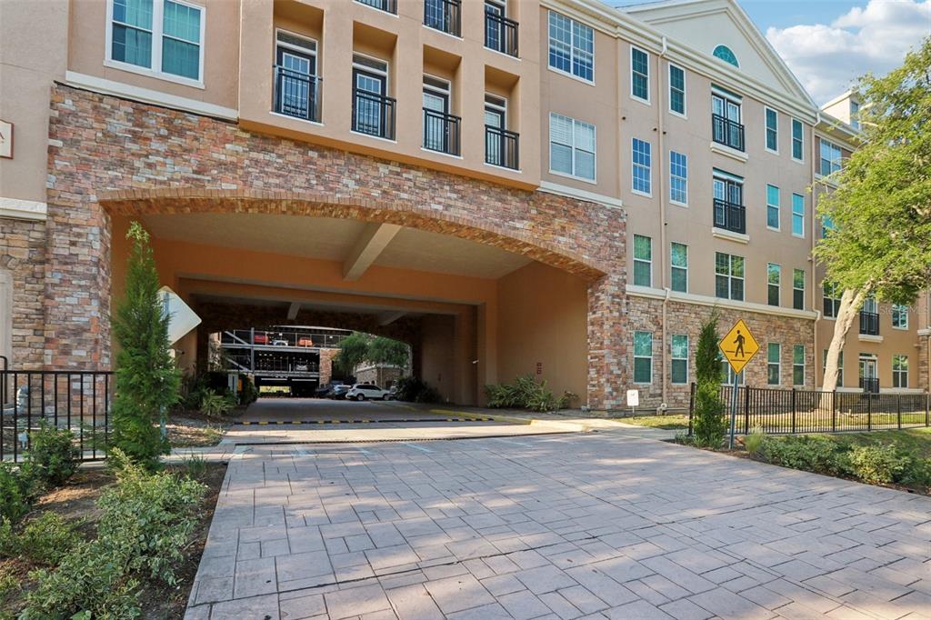 A paved driveway leads toward a stone-arched entryway of a multi-story apartment building — 4221 W SPRUCE STREET UNIT 2309, TAMPA, FL