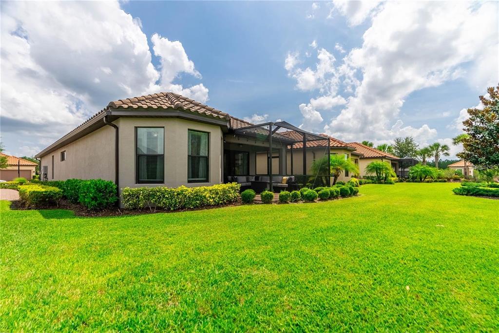The exterior view shows a house with a screened-in patio and a large grassy yard — 8412 ALBERATA VISTA DRIVE, TAMPA, FL