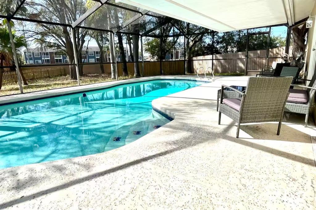 A screened-in swimming pool with a patio and outdoor seating area — 6506 SEAFAIRER DRIVE, TAMPA, FL