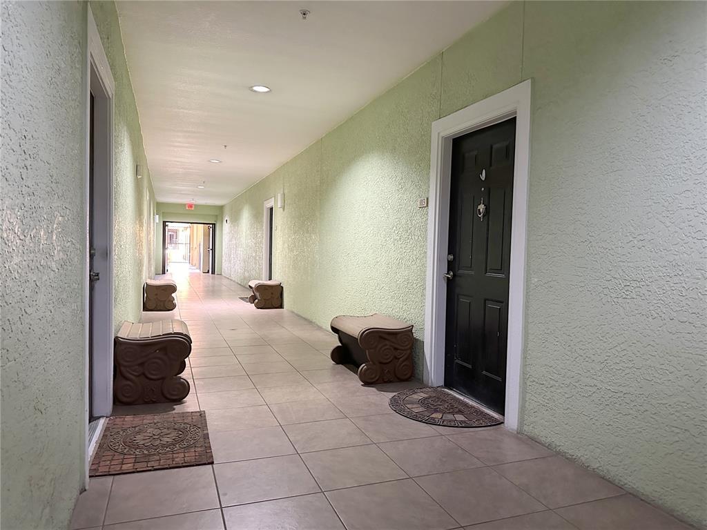 A multi-story brick commercial building features arched ground-floor windows, a balcony, and potted palm trees — 1810 E PALM AVENUE UNIT 1113, TAMPA, FL