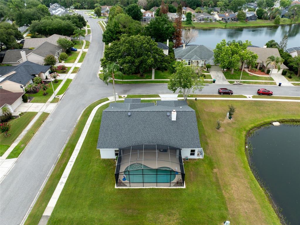 An aerial view shows a house with a screened-in pool and a lake in back — 14502 POTANOW TRAIL, ORLANDO, FL