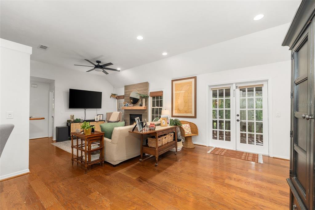 A living room with hardwood floors, a fireplace, a ceiling fan, and French doors — 5225 SW 86TH TERRACE, GAINESVILLE, FL
