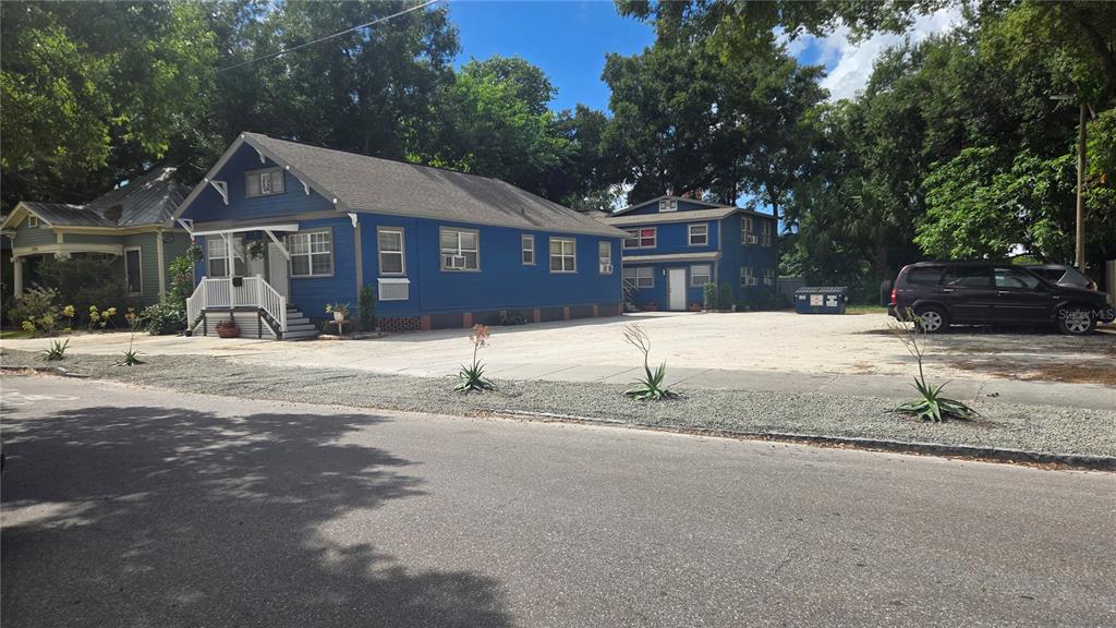 A blue house and a detached two-story building sit on a large gravel parking lot — 2306 N MORGAN STREET, TAMPA, FL