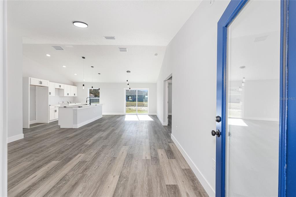 A covered porch with light gray siding, a blue door, and a wood-paneled ceiling — 15308 SW 56TH TERRACE ROAD, OCALA, FL