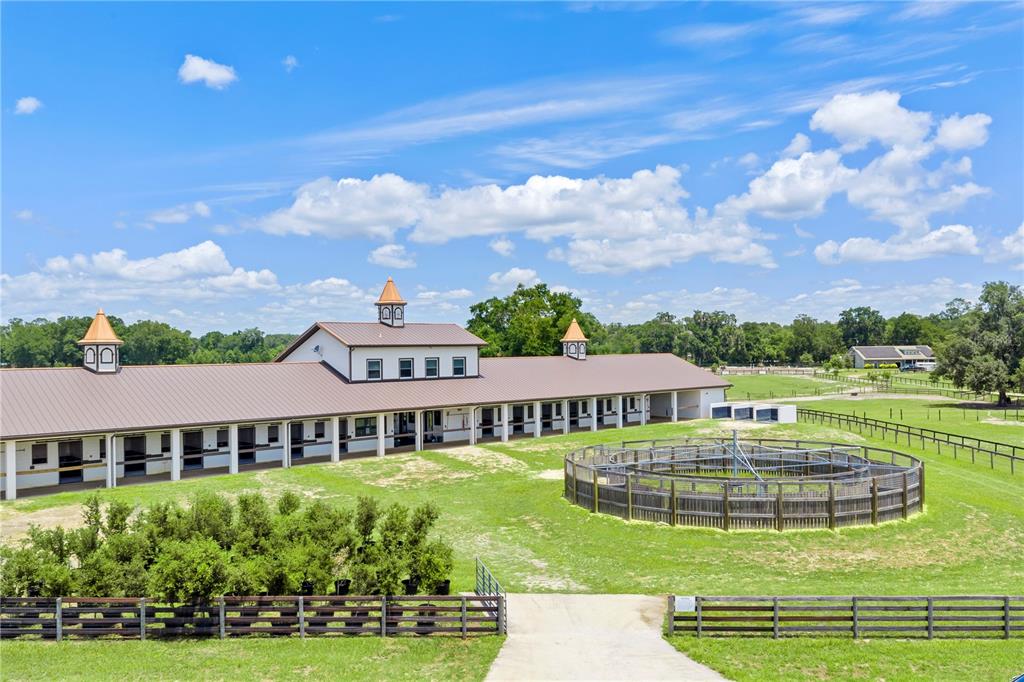 An aerial view of a horse stable with a circular exercise ring and fenced pastures — 1345 NE 155TH PLACE, CITRA, FL