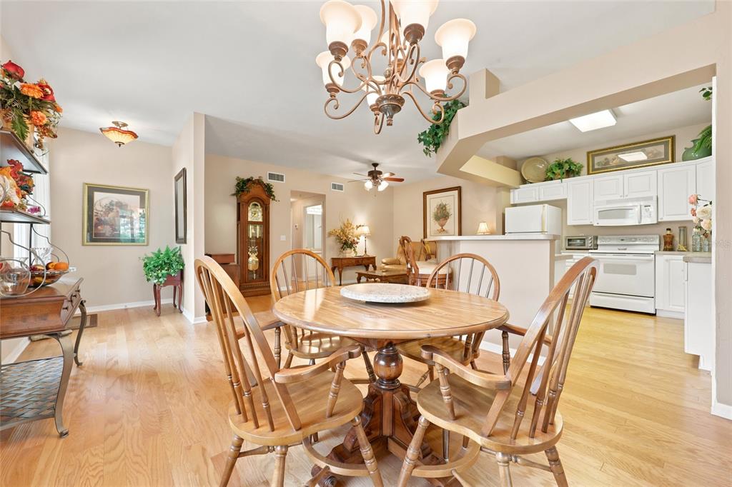 A dining area with a wooden table and chairs sits adjacent to an open kitchen — 2760 NW 105TH DRIVE, GAINESVILLE, FL