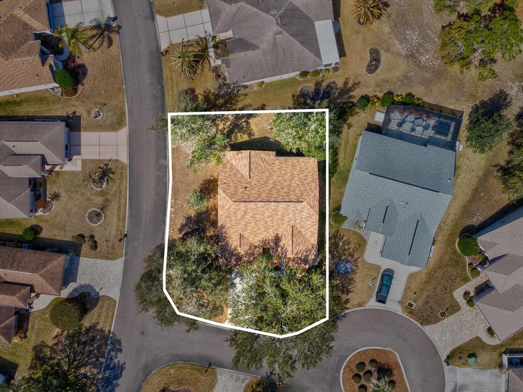 An aerial view shows a house with a tan roof situated on a corner lot — 3123 QUAIL HOLLOW COURT, SPRING HILL, FL