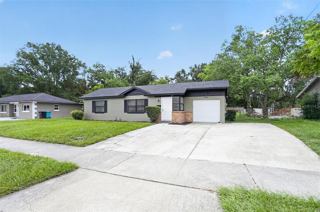 A single-story house with a gray exterior, white garage door, and a concrete driveway — 3402 LEWIS COURT, ORLANDO, FL