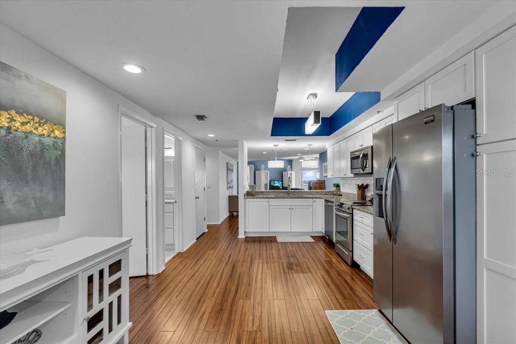 A kitchen with white cabinets, stainless steel appliances, and a blue-accented ceiling feature — 5621 GULF OF MEXICO DRIVE UNIT 102, LONGBOAT KEY, FL