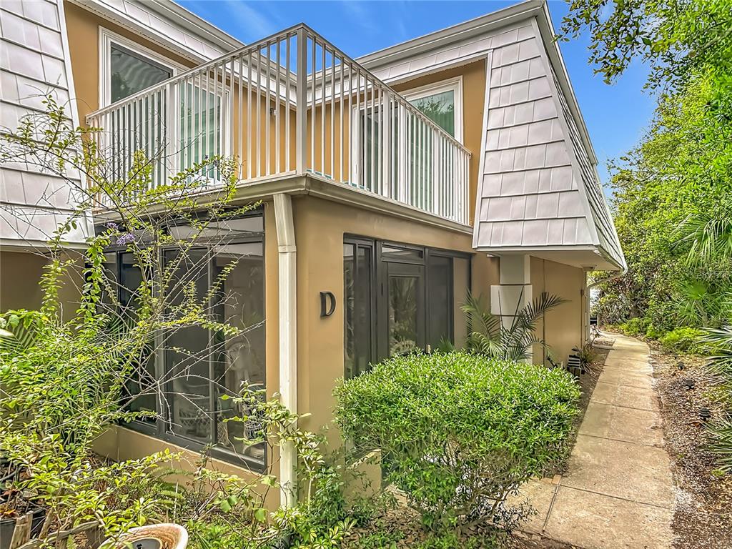 A two-story building exterior features a screened-in ground floor, a balcony, and a letter D — 4150 S ATLANTIC AVENUE UNIT 113D, NEW SMYRNA BEACH, FL
