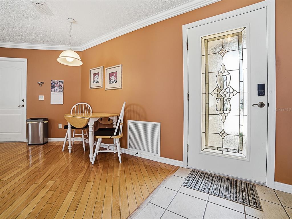 A dining area with a small table, two chairs, and a front door with glass — 7631 SE 170TH LONGVIEW LANE, THE VILLAGES, FL