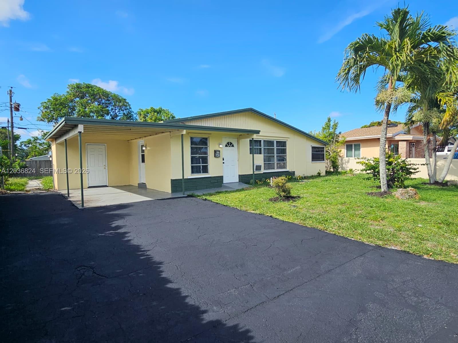 A yellow single-story house with a carport, asphalt driveway, and a palm tree in front — 649 NW 19th St, Pompano Beach FL 33060, POMPANO BEACH, FL