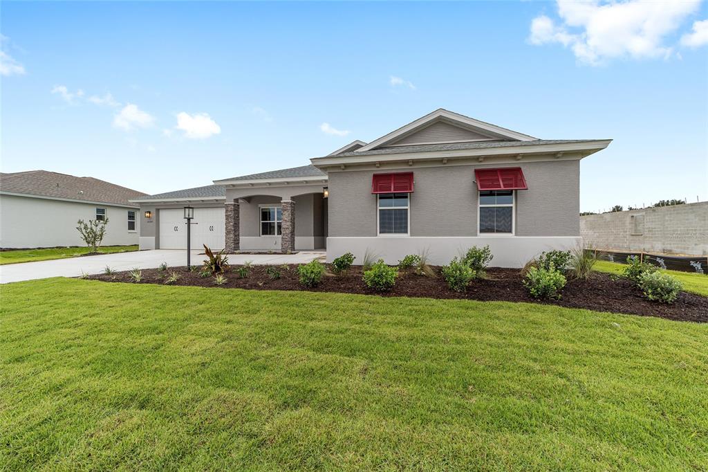 A single-story gray house with red window shutters and a stone-accented front porch — 10305 SW 105TH TERRACE, OCALA, FL