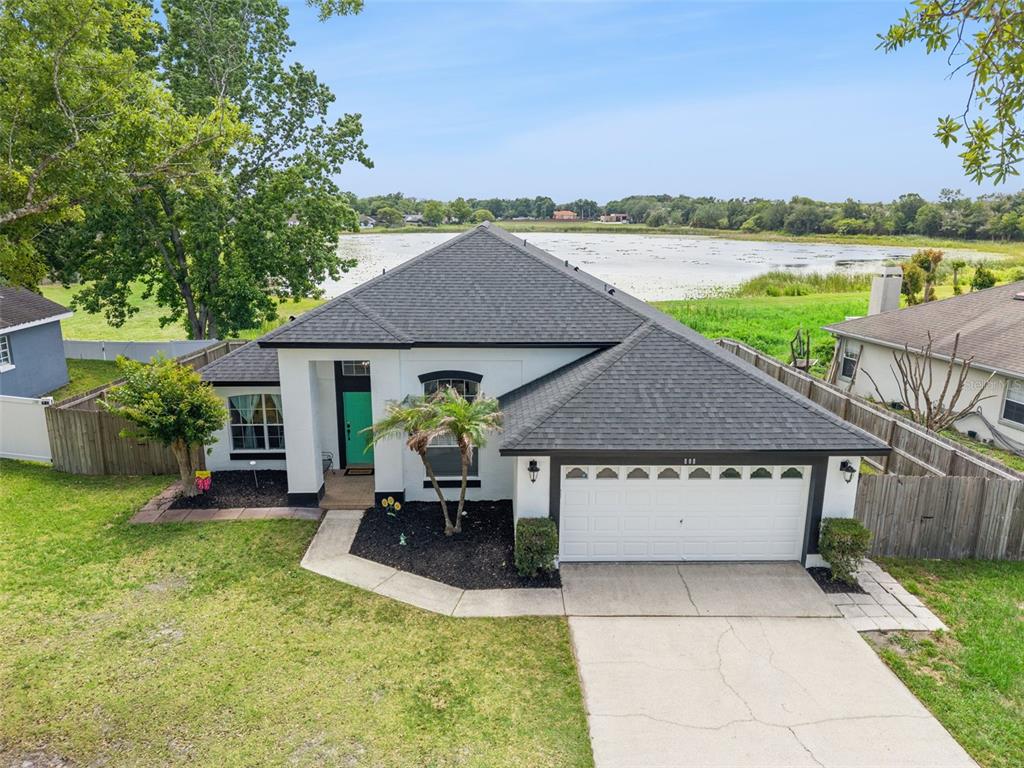 An aerial view shows a single-story house with a white exterior, dark roof, and garage — 808 LAKE JACKSON CIRCLE, APOPKA, FL