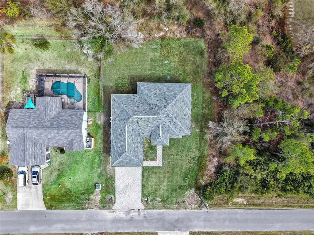 An aerial view shows two houses with shingled roofs, a swimming pool, and surrounding trees — 6192 KAMBACH STREET, PORT CHARLOTTE, FL