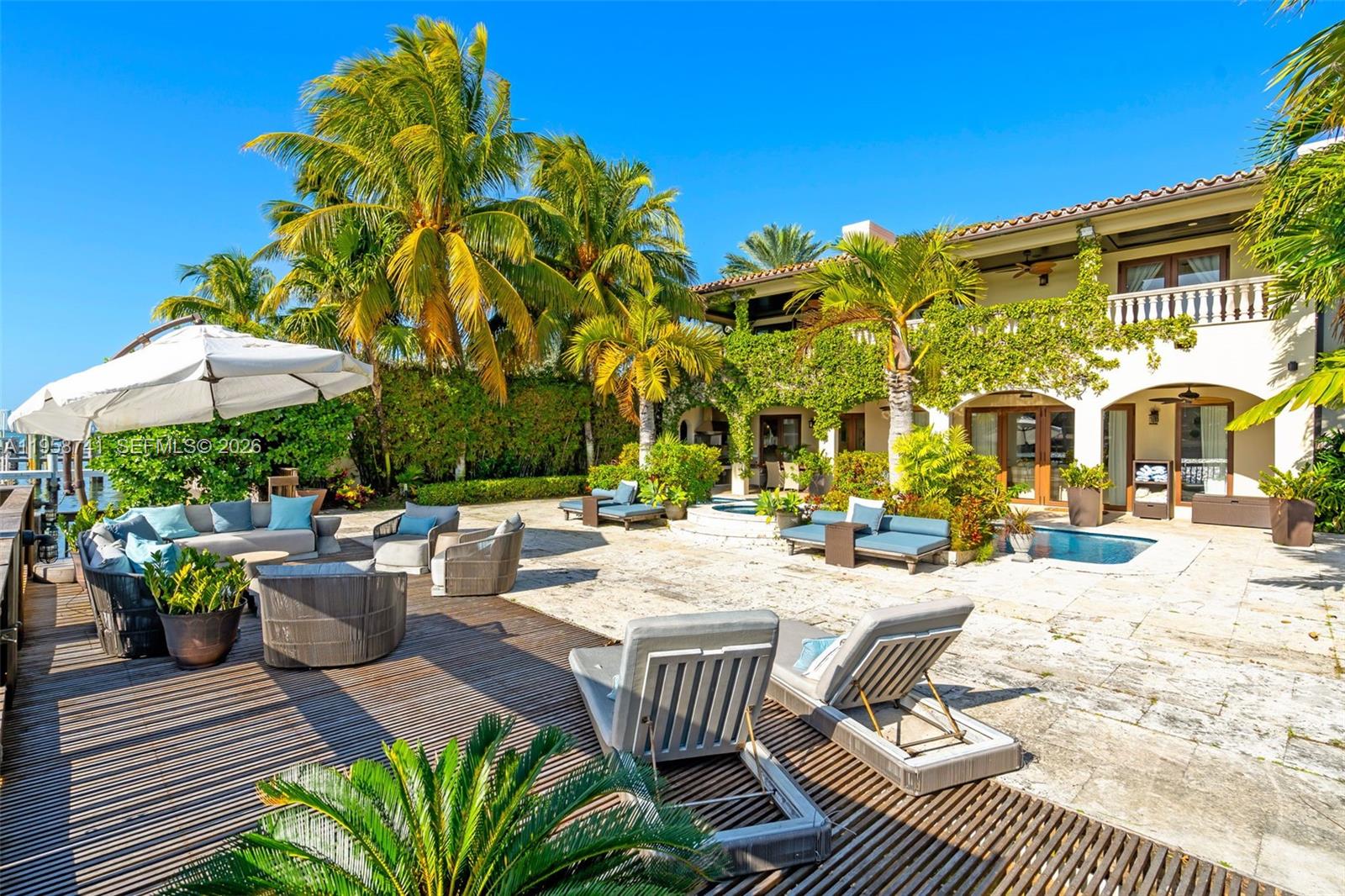 A spacious outdoor patio features a swimming pool, lounge seating, and palm trees — 1398 Bay Dr, Miami Beach FL 33141, MIAMI BEACH, FL