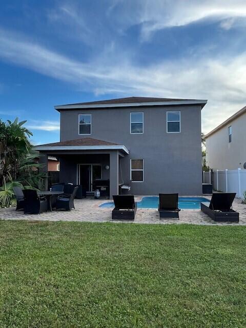 The exterior of a two-story gray house features a covered patio and a swimming pool — 144 Blue Grotto Drive, Fort Pierce FL 34945, FORT PIERCE, FL