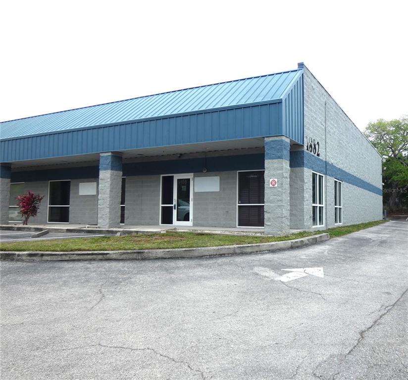 A single-story commercial building with a blue metal roof and gray concrete block walls — 1882 PORTER LAKE DRIVE UNIT 103, 106, 107, 108, SARASOTA, FL