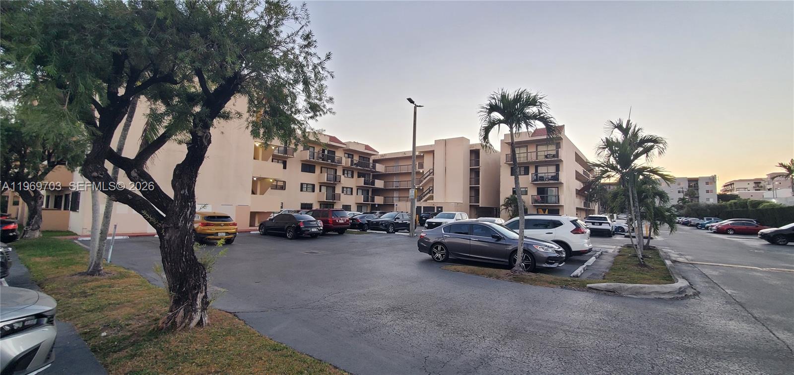 An exterior view of a multi-story apartment building with a parking lot in front — 995 SW 84th Ave # 218, Miami FL 33144, MIAMI, FL