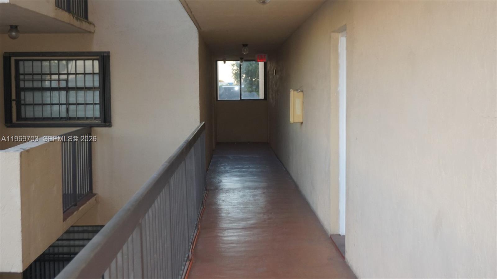 An outdoor apartment hallway features a metal railing, a window, and a concrete floor — 995 SW 84th Ave # 218, Miami FL 33144, MIAMI, FL