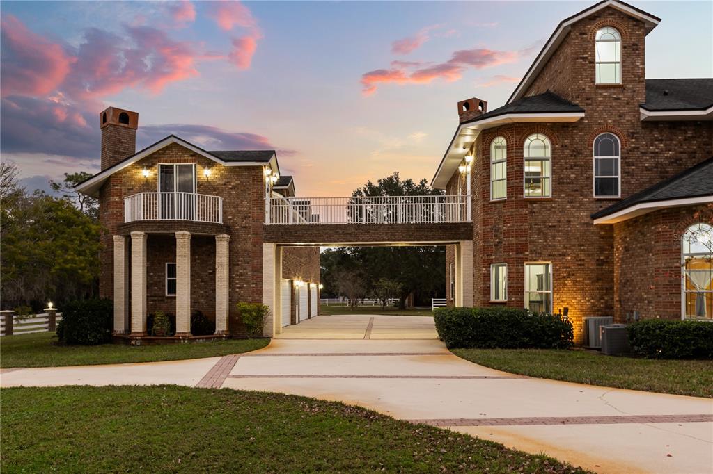 A two-story brick house with a bridge connecting two wings over a paved driveway — 1501 LAKE MARKHAM ROAD, SANFORD, FL