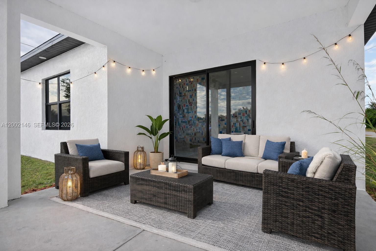 A covered patio features wicker furniture, a gray area rug, and string lights — 2513 69TH ST W, Lehigh Acres FL 33971, LEHIGH ACRES, FL