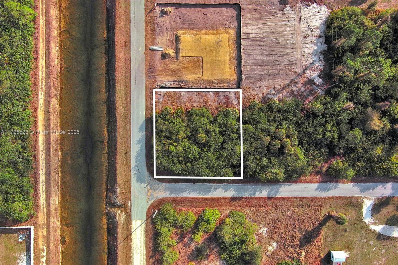 This aerial view shows a rectangular, wooded plot of land outlined in white — 4506 E 19th St, Lehigh Acres FL 33973, LEHIGH ACRES, FL