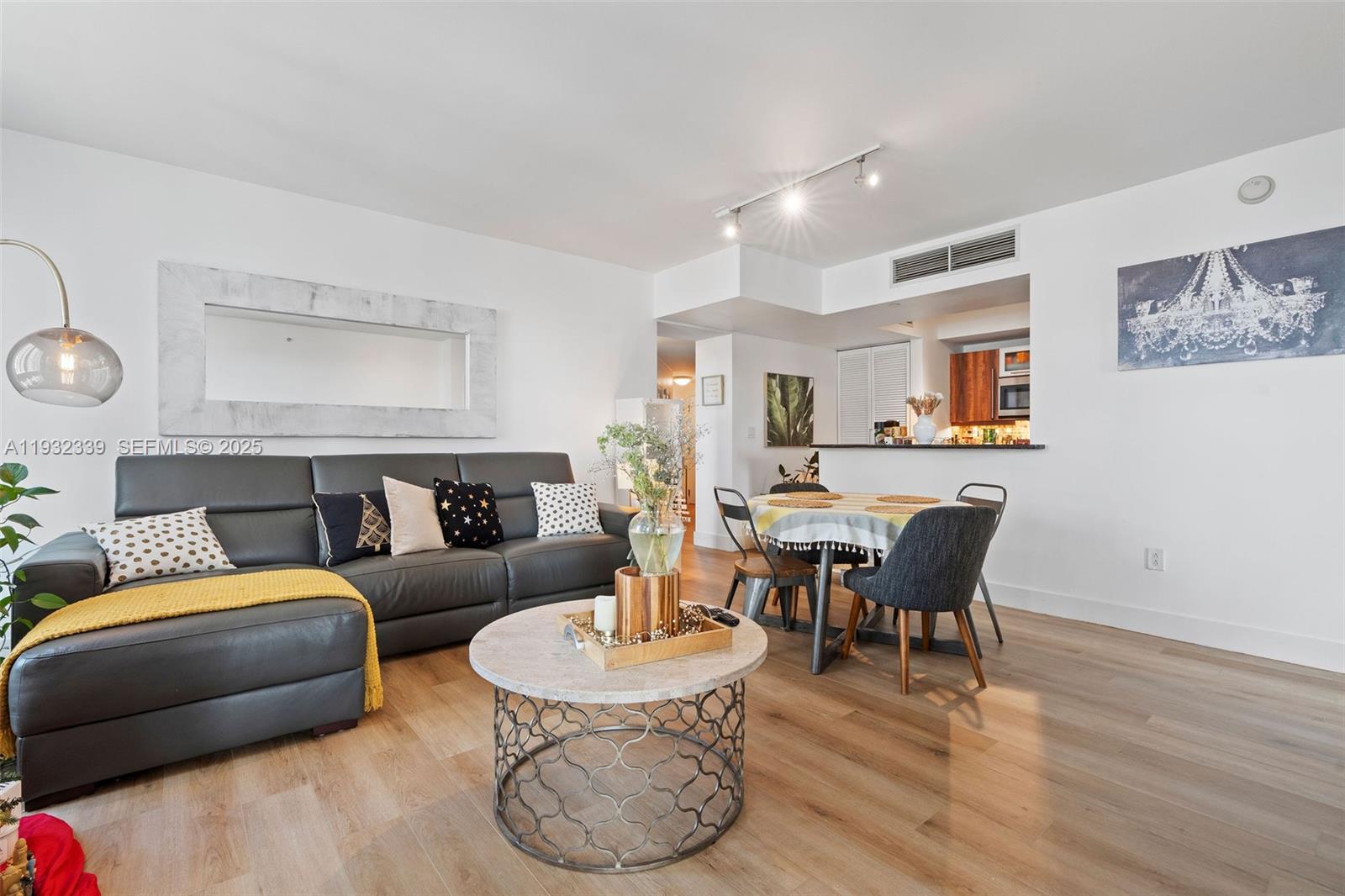 A living room and dining area feature a grey sofa, round coffee table, and kitchen — 7350 SW 89th St # 1110S, Miami FL 33156, MIAMI, FL