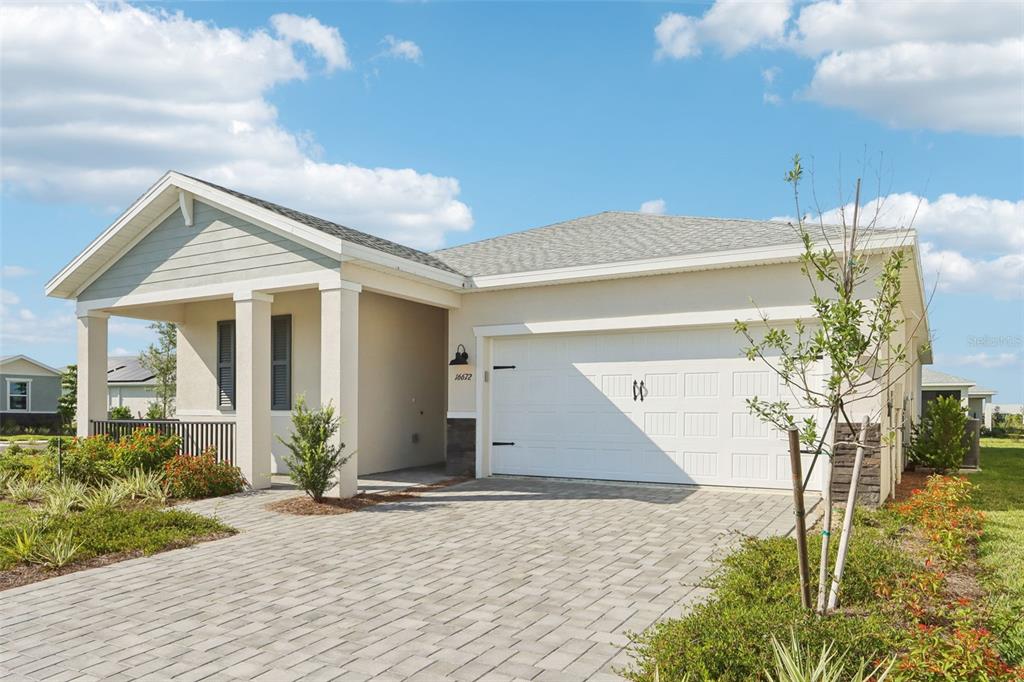 A single-story house with a paved driveway, white garage door, and a covered front porch — 16672 EXPEDITION COURT, PUNTA GORDA, FL