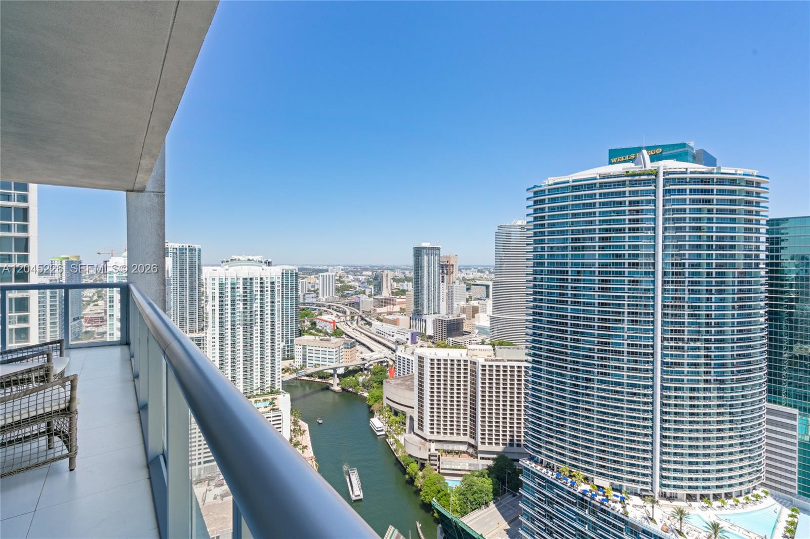 A high-rise balcony overlooks a river, highway, and surrounding city skyline in Miami — 475 Brickell Ave # 4315, Miami FL 33131, MIAMI, FL