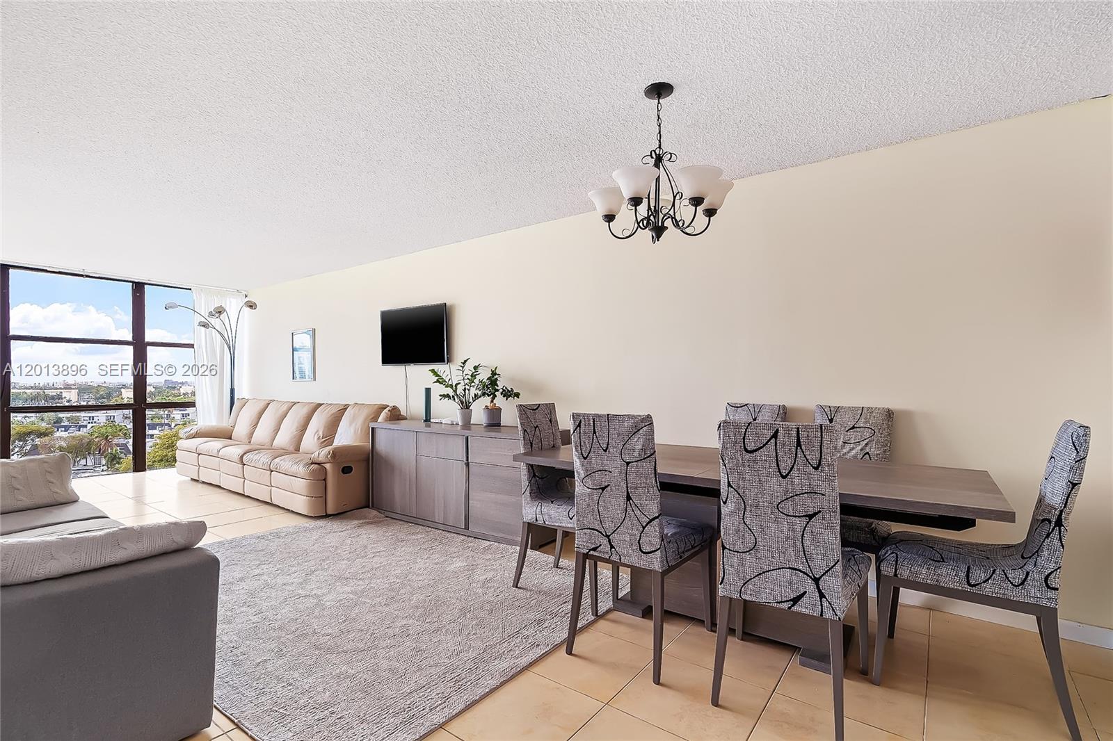 A living and dining area features tile flooring, a beige sofa, and patterned dining chairs — 800 Parkview Dr # 901, Hallandale Beach FL 33009, HALLANDALE BEACH, FL